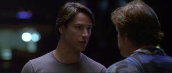 Movie still from “Point Break” (1991), directed by Kathryn Bigelow – A person talking to another person; Close Up shot, Over the shoulder angle