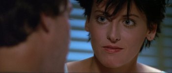Movie still from “Point Break” (1991), directed by Kathryn Bigelow – A woman's face as a man looks on; Close Up shot, Over the shoulder angle