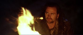 Movie still from “Point Break” (1991), directed by Kathryn Bigelow – A person with a fire in the background; Close Up shot, Over the shoulder angle