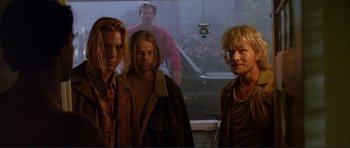 Movie still from “Point Break” (1991), directed by Kathryn Bigelow – A group of men standing next to each other; Medium shot, Low angle