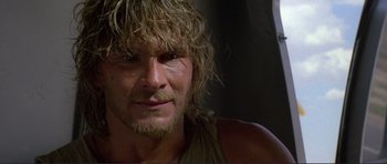 Movie still from “Point Break” (1991), directed by Kathryn Bigelow – A person with long hair and a beard; Close Up shot, Low angle