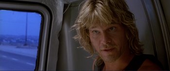 Movie still from “Point Break” (1991), directed by Kathryn Bigelow – A person with long blonde hair; Close Up shot, Over the shoulder angle