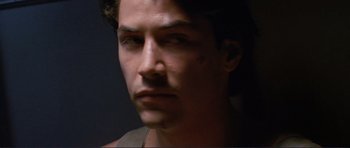 Movie still from “Point Break” (1991), directed by Kathryn Bigelow – A young man's face in the dark; Close Up shot, Over the shoulder angle