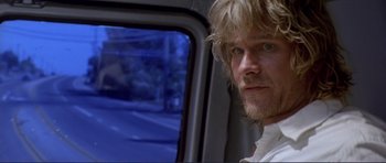 Movie still from “Point Break” (1991), directed by Kathryn Bigelow – A person in a car window; Close Up shot, Over the shoulder angle