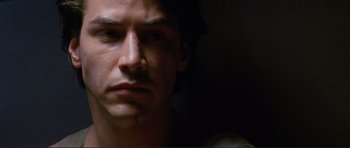 Movie still from “Point Break” (1991), directed by Kathryn Bigelow – A man's face in the dark; Close Up shot, Low angle