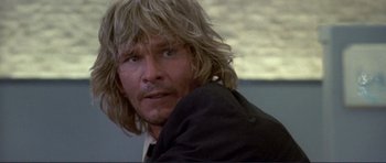 Movie still from “Point Break” (1991), directed by Kathryn Bigelow – A person with long blonde hair; Close Up shot, Low angle
