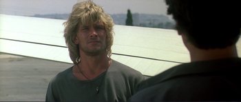 Movie still from “Point Break” (1991), directed by Kathryn Bigelow – A person with long blonde hair; Close Up shot, Low angle