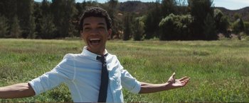 Movie still from “Pokémon: Detective Pikachu” (2019), directed by Rob Letterman – A young man in a white dress shirt and a black neck tie; Medium shot, Low angle