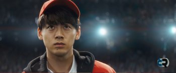 Movie still from “Pokémon: Detective Pikachu” (2019), directed by Rob Letterman – A young man in a baseball cap is looking at the camera; Close Up shot, Low angle