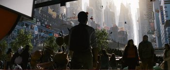 Movie still from “Pokémon: Detective Pikachu” (2019), directed by Rob Letterman – A man standing in front of a crowd of people in a city; Wide shot, High angle