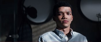 Movie still from “Pokémon: Detective Pikachu” (2019), directed by Rob Letterman – A young man in a white shirt is looking at the camera; Close Up shot, Low angle