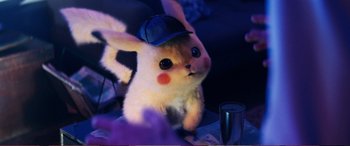 Movie still from “Pokémon: Detective Pikachu” (2019), directed by Rob Letterman – A stuffed animal with a hat on top of it; Close Up shot, Over the shoulder angle