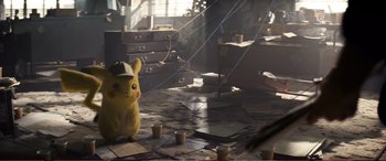 Movie still from “Pokémon: Detective Pikachu” (2019), directed by Rob Letterman – A pikachu toy sitting on top of a pile of papers; Medium shot, High angle