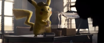 Movie still from “Pokémon: Detective Pikachu” (2019), directed by Rob Letterman – A stuffed pikachu is holding a coffee cup; Medium shot, Over the shoulder angle