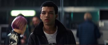 Movie still from “Pokémon: Detective Pikachu” (2019), directed by Rob Letterman – A man in a black jacket is looking at the camera; Close Up shot, Over the shoulder angle