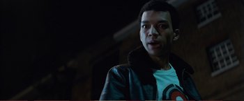 Movie still from “Pokémon: Detective Pikachu” (2019), directed by Rob Letterman – A young man wearing a leather jacket looking at the camera; Close Up shot, Low angle