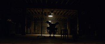 Movie still from “Pokémon: Detective Pikachu” (2019), directed by Rob Letterman – A person sitting on top of a chair in a dark room; Extreme Wide shot, Low angle