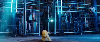 Movie still from “Pokémon: Detective Pikachu” (2019), directed by Rob Letterman – A group of people standing around a stuffed animal; Wide shot, Low angle