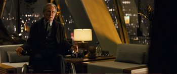 Movie still from “Pokémon: Detective Pikachu” (2019), directed by Rob Letterman – A man sitting on a chair in front of a lamp; Medium shot, Over the shoulder angle