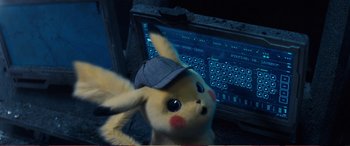 Movie still from “Pokémon: Detective Pikachu” (2019), directed by Rob Letterman – A stuffed animal wearing a hat next to a computer keyboard; Close Up shot, High angle