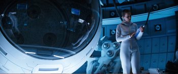 Movie still from “Pokémon: Detective Pikachu” (2019), directed by Rob Letterman – A woman standing in front of a mirror in a room; Medium shot, Low angle