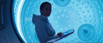 Movie still from “Pokémon: Detective Pikachu” (2019), directed by Rob Letterman – A woman is holding a tablet computer in her hands; Medium shot, Low angle