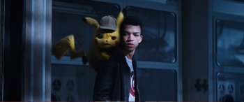 Movie still from “Pokémon: Detective Pikachu” (2019), directed by Rob Letterman – A man holding a pikachu in his arms; Close Up shot, Over the shoulder angle