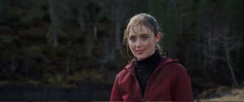 Movie still from “Pokémon: Detective Pikachu” (2019), directed by Rob Letterman – A young woman in a red jacket standing in front of a forest; Close Up shot, Over the shoulder angle