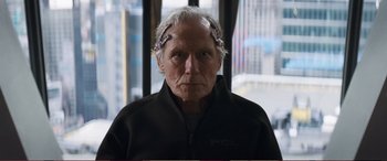 Movie still from “Pokémon: Detective Pikachu” (2019), directed by Rob Letterman – An older man with white hair and some hair clips on his head; Close Up shot, Over the shoulder angle