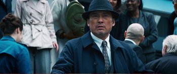 Movie still from “Pokémon: Detective Pikachu” (2019), directed by Rob Letterman – An older man in a hat and a tie; Medium shot, Over the shoulder angle
