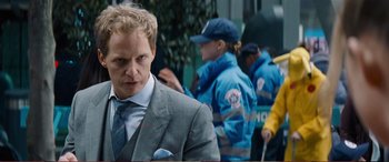 Movie still from “Pokémon: Detective Pikachu” (2019), directed by Rob Letterman – A man in a gray suit and tie; Close Up shot, Over the shoulder angle