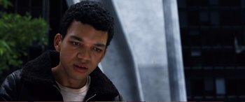 Movie still from “Pokémon: Detective Pikachu” (2019), directed by Rob Letterman – A young man with a black jacket is looking at the camera; Close Up shot, High angle