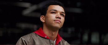 Movie still from “Pokémon: Detective Pikachu” (2019), directed by Rob Letterman – A young man in a brown and red jacket looking upward; Close Up shot, Low angle