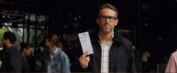 Movie still from “Pokémon: Detective Pikachu” (2019), directed by Rob Letterman – A man in a black jacket holding up a ticket; Close Up shot, Over the shoulder angle