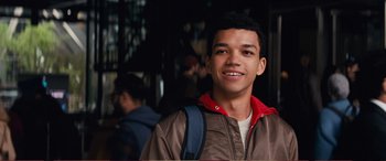 Movie still from “Pokémon: Detective Pikachu” (2019), directed by Rob Letterman – A young man wearing a brown and red jacket; Close Up shot, Over the shoulder angle