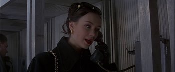 Movie still from “First Strike” (1996), directed by Stanley Tong – A woman talking on a phone while wearing gloves; Close Up shot, High angle