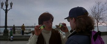 Movie still from “First Strike” (1996), directed by Stanley Tong – Two men are holding cans of food in front of each other; Close Up shot, Low angle