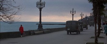 Movie still from “First Strike” (1996), directed by Stanley Tong – A car driving down a road next to the ocean; Extreme Wide shot, High angle