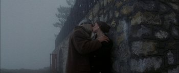 Movie still from “First Strike” (1996), directed by Stanley Tong – Two people kissing in front of a stone wall; Wide shot, High angle