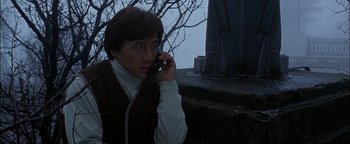 Movie still from “First Strike” (1996), directed by Stanley Tong – A man talking on a cell phone while sitting on steps; Close Up shot, Low angle