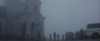 Movie still from “First Strike” (1996), directed by Stanley Tong – A group of people standing in front of a building in the fog; Extreme Wide shot, Low angle