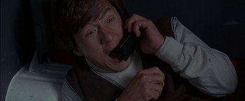 Movie still from “First Strike” (1996), directed by Stanley Tong – A man holding a cell phone up to his ear; Close Up shot, Overhead angle