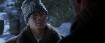 Movie still from “First Strike” (1996), directed by Stanley Tong – A man wearing a hat and glasses talking to another man; Close Up shot, Over the shoulder angle