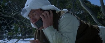 Movie still from “First Strike” (1996), directed by Stanley Tong – A man wearing a white hat talking on a cell phone; Close Up shot, Low angle