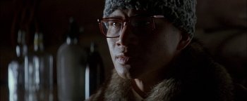 Movie still from “First Strike” (1996), directed by Stanley Tong – A person wearing glasses and a fur coat; Close Up shot, Low angle