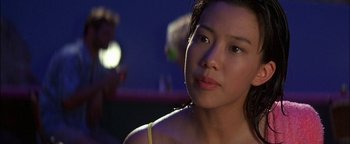 Movie still from “First Strike” (1996), directed by Stanley Tong – A young woman is looking into the camera; Close Up shot, Over the shoulder angle
