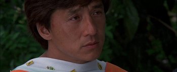 Movie still from “First Strike” (1996), directed by Stanley Tong – A person wearing a white and orange shirt; Close Up shot, Low angle