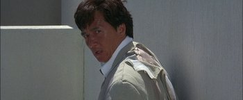 Movie still from “First Strike” (1996), directed by Stanley Tong – A person wearing a suit and tie; Close Up shot, Low angle