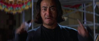 Movie still from “First Strike” (1996), directed by Stanley Tong – A person with long black hair; Close Up shot, Low angle