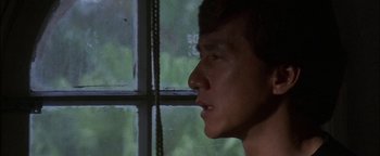 Movie still from “First Strike” (1996), directed by Stanley Tong – A man looking out of a window at the trees; Close Up shot, Low angle